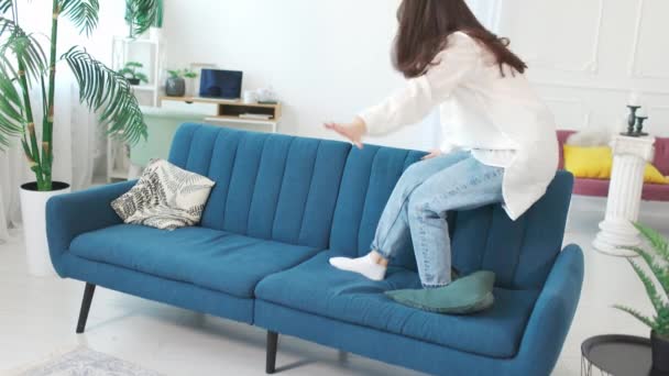 Mujer bastante alegre saltando en el sofá. — Vídeos de Stock