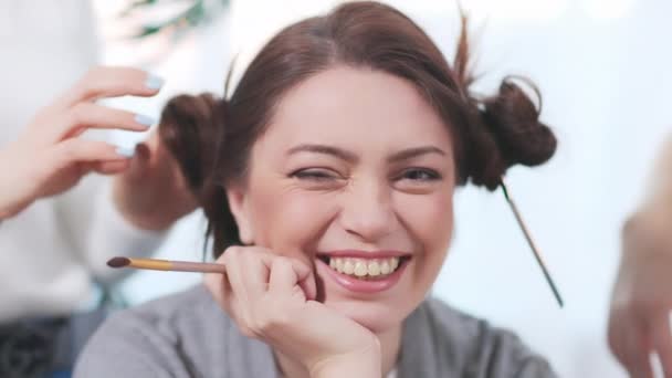 Las hembras haciendo el peinado divertido a la mujer joven bonita. — Vídeos de Stock