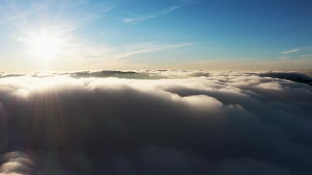 Sol skiner klart över vita fluffiga moln vid soluppgången — Stockvideo