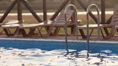 Günbatımı arka planında temiz suyla yüzme havuzunun en üst manzarası