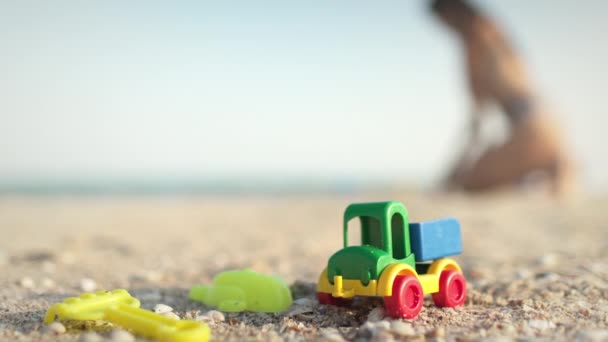 Sok játék fekszik a tengerparton, közel a tengerhez a nyári nap alatt. — Stock videók