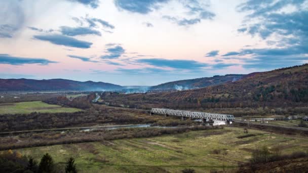 Puente del ferrocarril sobre el río en el valle de las tierras altas al atardecer — Vídeos de Stock