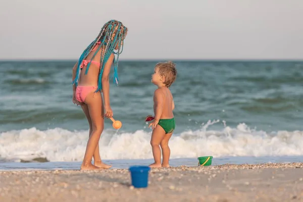 Sœur aînée jouant avec frère cadet échoué près de la rive en vacances d'été — Photo