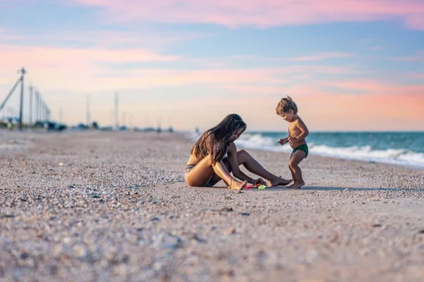A nővére játszik az öccsével zátonyra futott a parton a nyári vakáción. — Stock Fotó