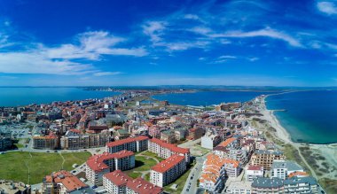 Bulgaristan 'da açık bir günde, deniz yayı turkuvaz Karadeniz tarafından yıkanan, eski Avrupa' daki küçük evleri ve sessiz sakin caddeleri olan küçük Pomorie tatil beldesine panoramik kuş bakışı bakış