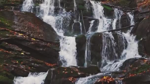 Wodospad spadający z zbocza góry w jesiennym lesie — Wideo stockowe