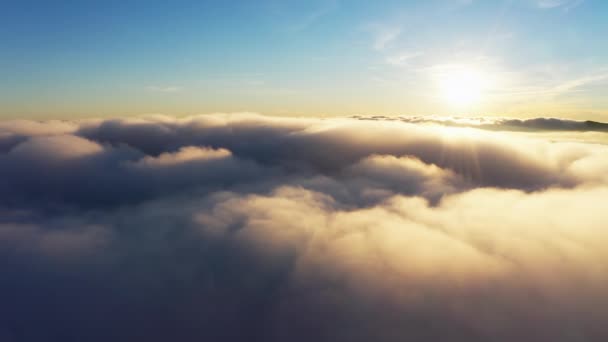 Zon schijnt helder boven witte pluizige wolken bij zonsopgang — Stockvideo