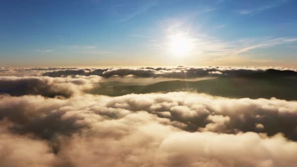 Aurinko paistaa kirkkaasti valkoisten pörröisten pilvien yläpuolella auringonnousun aikaan — kuvapankkivideo
