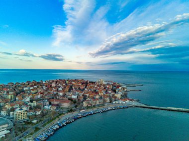 Panoramic bird's eye view over small ancient resort town of Pomorie with old European small houses and quiet calm empty streets, washed by the sea spring turquoise Black Sea on clear day in Bulgaria
