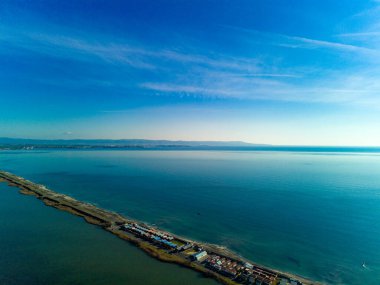 Bulgaristan 'da açık bir günde, deniz yayı turkuvaz Karadeniz tarafından yıkanan, eski Avrupa' daki küçük evleri ve sessiz sakin caddeleri olan küçük Pomorie tatil beldesine panoramik kuş bakışı bakış