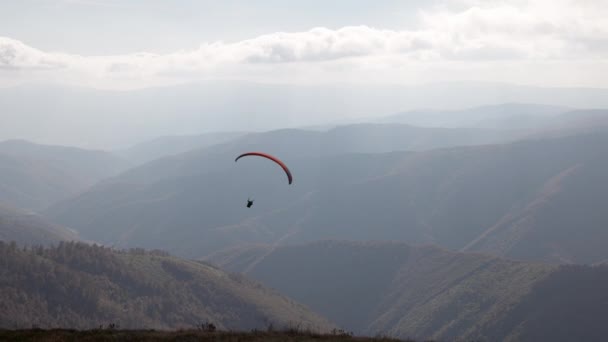 Parapente esporte ativo contra montanhas gigantes no planalto — Vídeo de Stock