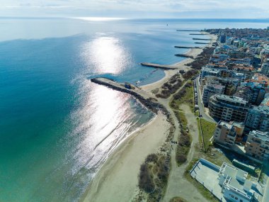 Bulgaristan 'da açık bir günde, deniz yayı turkuvaz Karadeniz tarafından yıkanan, eski Avrupa' daki küçük evleri ve sessiz sakin caddeleri olan küçük Pomorie tatil beldesine panoramik kuş bakışı bakış