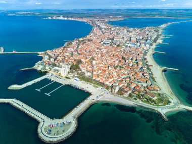Panoramic bird's eye view over small ancient resort town of Pomorie with old European small houses and quiet calm empty streets, washed by the sea spring turquoise Black Sea on clear day in Bulgaria