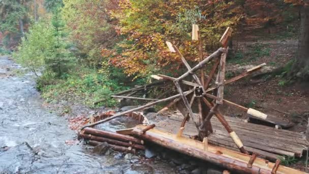 Kvarnen driver vattnet i älven i höstskogen i molnigt väder — Stockvideo