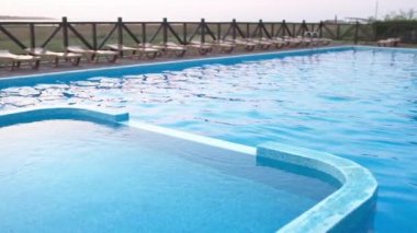 Günbatımı arka planında temiz suyla yüzme havuzunun en üst manzarası