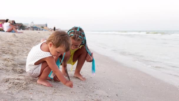 Sorella maggiore che gioca con il fratello più giovane arenato vicino alla riva in vacanza estiva — Video Stock