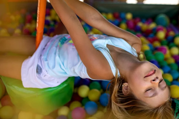 Girl in a T-shirt spends time in the playroom enjoying a summer day — Stock Photo, Image