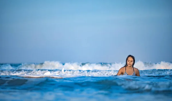 Leopar mayo giymiş ıslak saçlı kız denizde otururken su sıçratıyor. — Stok fotoğraf