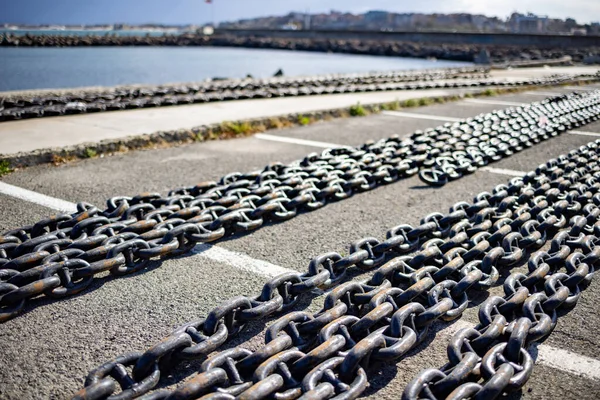 Chaînes pour navires se trouve sur la jetée sur le fond d'un ciel nuageux et la mer Noire — Photo