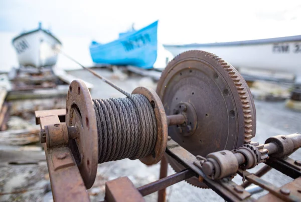 Winch con una cuerda en un muelle con barcos y botes contra el cielo — Foto de Stock