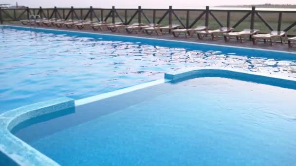 Vista superior de la piscina con agua clara de vacaciones en el fondo del atardecer — Vídeos de Stock