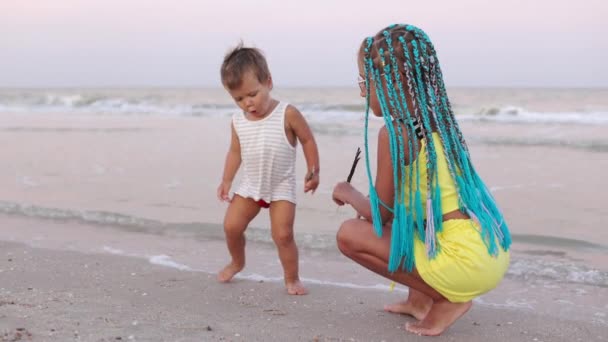 Kakak perempuan bermain dengan adik kandas dekat pantai pada liburan musim panas — Stok Video