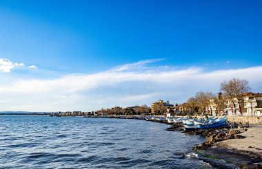 Sakin mavi Karadeniz 'deki büyüleyici büyüleyici yansımasını deniz ufkunun arka planında çok renkli bulutlu bir gökyüzü ve parlak bir akşam günbatımında görüyorum.