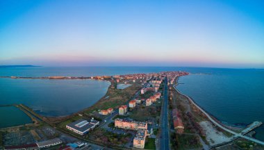 Bulgaristan 'da açık bir günde, deniz yayı turkuvaz Karadeniz tarafından yıkanan, eski Avrupa' daki küçük evleri ve sessiz sakin caddeleri olan küçük Pomorie tatil beldesine panoramik kuş bakışı bakış