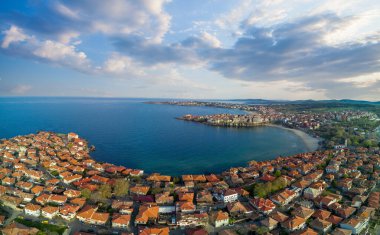 Bulgaristan 'da açık bir günde, deniz yayı turkuvaz Karadeniz tarafından yıkanan, eski Avrupa' daki küçük evleri ve sessiz sakin caddeleri olan küçük Pomorie tatil beldesine panoramik kuş bakışı bakış