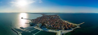 Bulgaristan 'da açık bir günde, deniz yayı turkuvaz Karadeniz tarafından yıkanan, eski Avrupa' daki küçük evleri ve sessiz sakin caddeleri olan küçük Pomorie tatil beldesine panoramik kuş bakışı bakış