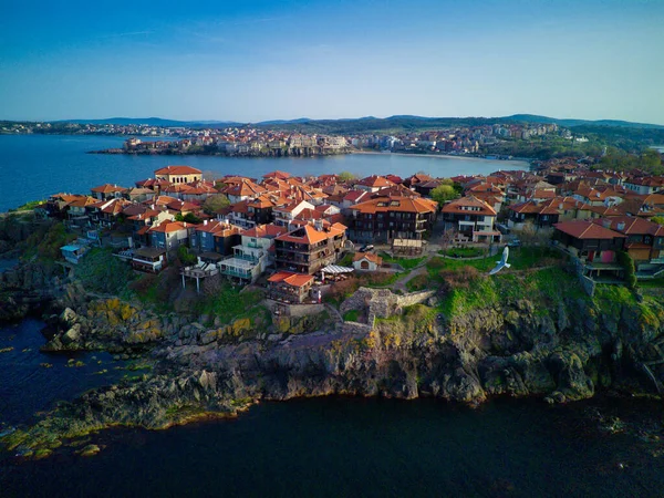 Bird\'s eye view of the small spring green town of Nessebar with historic ancient European houses and fresh blooming empty parks, washed by the calm porous deep Black Sea in Bulgaria