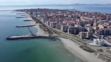 Bulgaristan 'ın kayalık yarımadasında bulunan ve büyük mavi, tuzlu Karadeniz tarafından turlanan küçük ve yoğun nüfuslu Pomorie kasabasına kuş bakışı bir bakış. UHD 4K video gerçek zamanlı