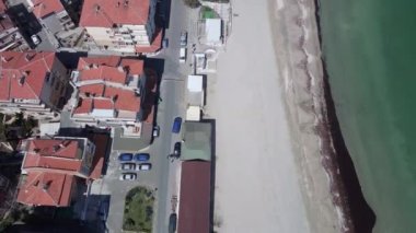 Bulgaristan 'ın kayalık yarımadasında bulunan ve büyük mavi, tuzlu Karadeniz tarafından turlanan küçük ve yoğun nüfuslu Pomorie kasabasına kuş bakışı bir bakış. UHD 4K video gerçek zamanlı