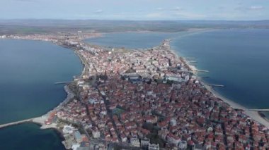 Bulgaristan 'ın kayalık yarımadasında bulunan ve büyük mavi, tuzlu Karadeniz tarafından turlanan küçük ve yoğun nüfuslu Pomorie kasabasına kuş bakışı bir bakış. UHD 4K video gerçek zamanlı