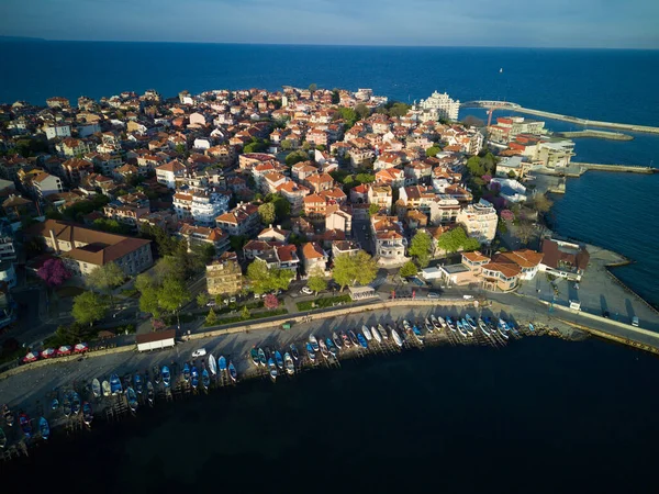Bulgaristan 'ın Pomorie kentindeki antik tatil beldesi Pomorie' nin arka planında, bulutlu, mavi bir gökyüzü altında, derin ve sakin Karadeniz kıyısında yürüyen insanlarla deniz gezintisi.