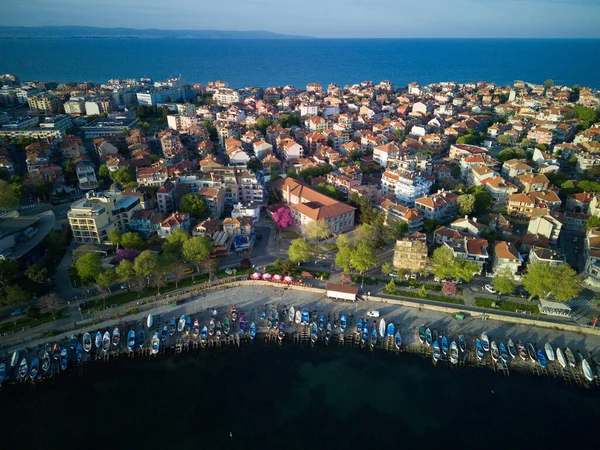 Bulgaristan 'ın Pomorie kentindeki antik tatil beldesi Pomorie' nin arka planında, bulutlu, mavi bir gökyüzü altında, derin ve sakin Karadeniz kıyısında yürüyen insanlarla deniz gezintisi.