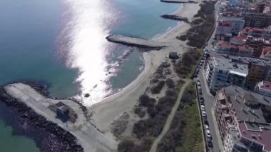 Bulgaristan 'ın kayalık yarımadasında bulunan ve büyük mavi, tuzlu Karadeniz tarafından turlanan küçük ve yoğun nüfuslu Pomorie kasabasına kuş bakışı bir bakış. UHD 4K video gerçek zamanlı
