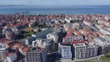Bulgaristan 'ın kayalık yarımadasında bulunan ve büyük mavi, tuzlu Karadeniz tarafından turlanan küçük ve yoğun nüfuslu Pomorie kasabasına kuş bakışı bir bakış. UHD 4K video gerçek zamanlı