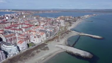 Bulgaristan 'ın kayalık yarımadasında bulunan ve büyük mavi, tuzlu Karadeniz tarafından turlanan küçük ve yoğun nüfuslu Pomorie kasabasına kuş bakışı bir bakış. UHD 4K video gerçek zamanlı