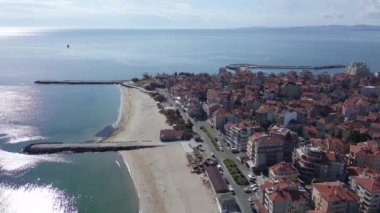 Bulgaristan 'ın kayalık yarımadasında bulunan ve büyük mavi, tuzlu Karadeniz tarafından turlanan küçük ve yoğun nüfuslu Pomorie kasabasına kuş bakışı bir bakış. UHD 4K video gerçek zamanlı