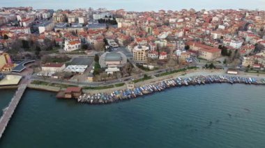 Küçük, yeni inşa edilmiş bir tatil köyünün kuş bakışı manzarası - Pomorie yarımadası, büyük, tuzlu, sakin Karadeniz 'de birçok farklı modern tekne ve tekne. UHD 4K video gerçek zamanlı