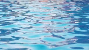 Büyük mavi bir havuzda, açık mavi bir su ve güneşin yansımaları. 4K UHD yavaş çekim videosu