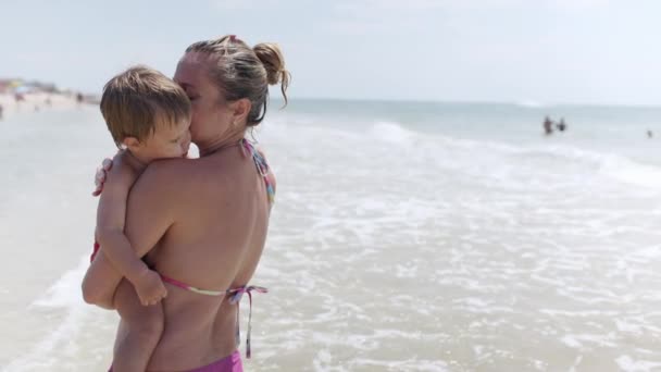 비키니를 자상하고 어머니가 해변의 근처에서 아래서 귀여운 아기를 Uhd Slow — 비디오