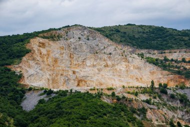 Dağlar arası yol kenarında, geniş yeşil ladin ormanları ve dağ bitkilerine sahip Rodop Dağları 'nın ve tepelerin ardında, zengin bir maden ocağı bulunur.