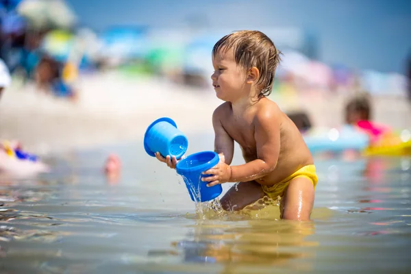 Маленький Забавный Малыш Собирает Раковины Гальку Спокойном Синем Море Песчаном — стоковое фото