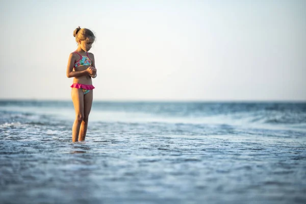 小さな波で遊んで面白い細い陽気な女の子 足を蹴り 暖かい明るい夏の太陽の下で所定の位置に回転待望の休暇を楽しんで — ストック写真