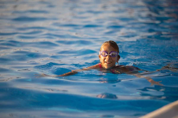 Mała Dziewczynka Jasnoróżowym Kostiumie Kąpielowym Przezroczystymi Czarnymi Goglami Pływania Prostuje — Zdjęcie stockowe
