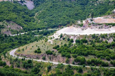 Dağlar arası yol kenarında, geniş yeşil ladin ormanları ve dağ bitkilerine sahip Rodop Dağları 'nın ve tepelerin ardında, zengin bir maden ocağı bulunur.