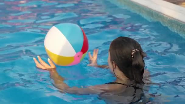 Young Girl Bright Leopard Swimsuit Swims Bright Colored Inflatable Ball — Video Stock