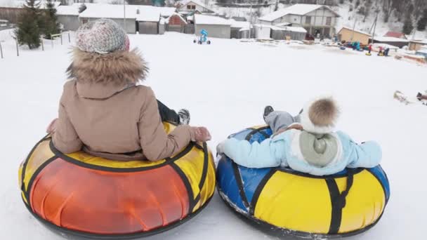 Back View Young Teenage Girls Riding Yellow Snow Tubes Snowy — Stock Video